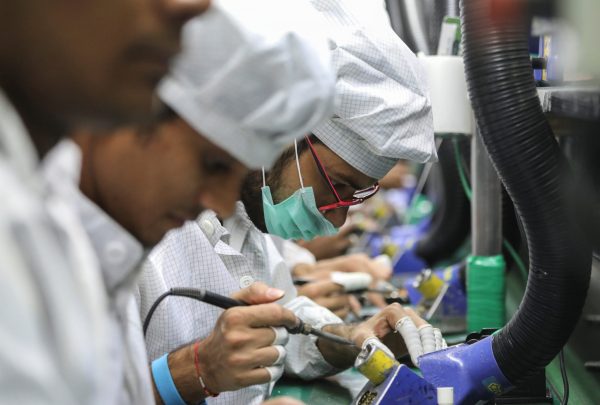 Workers solder wires on printed circuit boards of a mobile handset at Lava International Limited's manufacturing plant in Noida, India, 12 October 2018 (Photo: Reuters/Anushree Fadnavis)