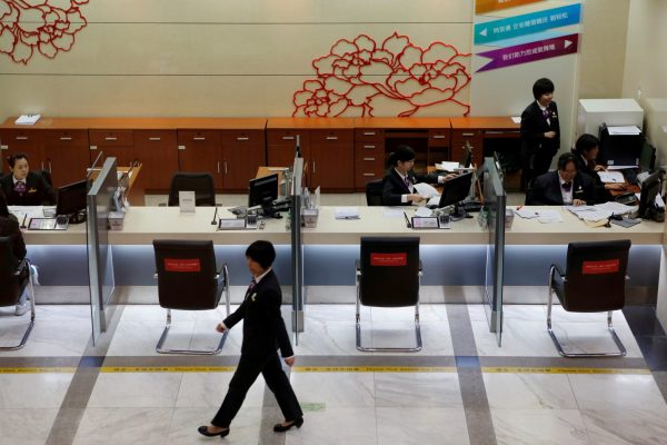 Staff members work at counters inside a branch of Industrial and Commercial Bank of China (ICBC) in Beijing, China. 1 April 2019. (Photo: Reuters/Florence Lo)