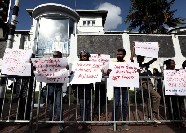 A group of Sri Lankans hold placards during a protest condemning signed death sentences for four people convicted of drug-related offences in a decision by Sri Lanka's President Maithripala Sirisena, in front of the Welikada Prison in Colombo, Sri Lanka 28 June 2019. (Photo: Reuters/ Dinuka Liyanawatte).