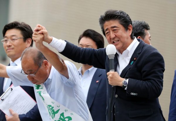 Japanese Prime Minister and leader of the ruling Liberal Democratic Party (LDP) Shinzo Abe raises hand of his party candidate Yoshiro Toyoda for the 21 July Upper House election in Ichikawa, Tokyo on 20 July 2019 (Photo: Reuters/Yoshio Tsunoda/AFLO).