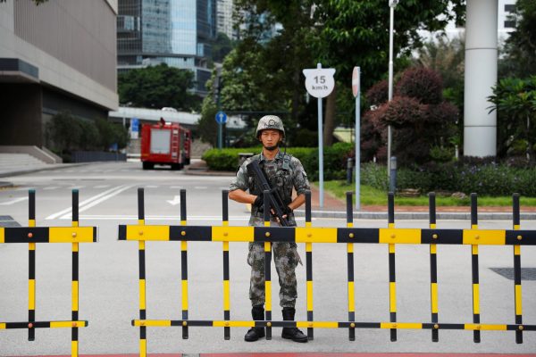 A Chinese People's Liberation Army (PLA) soldier guards the entrance to the PLA Hong Kong Garrison headquarters in the Central Business District in Hong Kong, China, 29 August, 2019. (Photo: Reuters/Anushree Fadnavis)