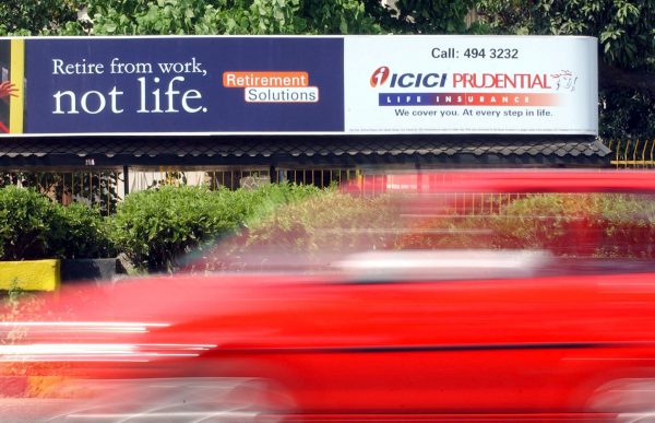 A vehicle passes a life insurance bill board of Prudential-ICICI in Bombay, India, 30 September 2002 (Photo: Reuters/Stringer JSG).