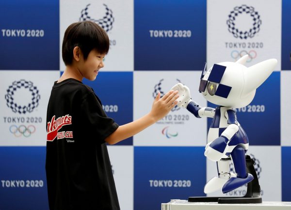 Tokyo 2020 mascot robot Miraitowa, which will be used to support the Tokyo 2020 Olympic and Paralympic Games, exchanges high-five with a boy during the robot unveiling event to celebrate the first anniversary of the mascot debut at Tokyo Stadium in Tokyo, Japan. 22 July 2019, (Photo: Reuters/Issei Kato).