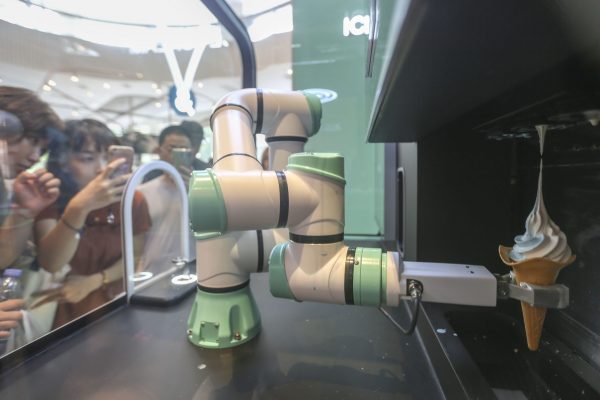 A robot arm makes an ice cream for customers at a fastfood restaurant of KFC in Shanghai, China, 25 August 2019 (Photo: Reuters).