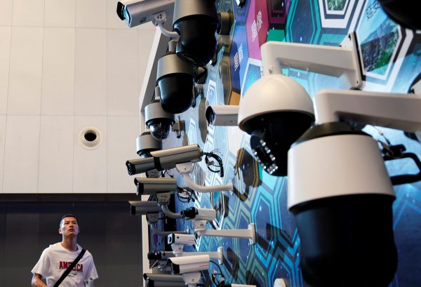 A man wears a t-shirt with the wording ‘America’ as he looks at surveillance cameras displayed at Huawei's booth at the security exhibition in Shanghai, China, 24 May 2019 (Photo: Reuters/Aly Song).