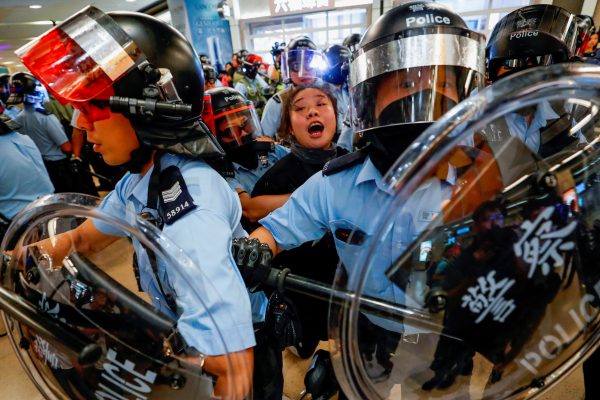 Riot police detain a woman as anti-government protesters gather at Sha Tin Mass Transit Railway (MTR) station in Hong Kong, China, 25 September 2019 (Photo: Reuters/Tyrone Siu/File Photo).