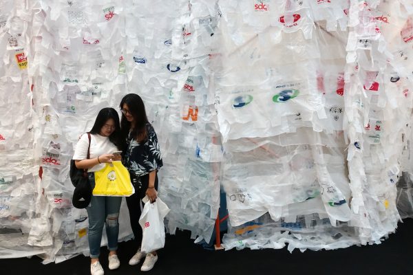 Tourists hold up their plastic bags as they stand next to the art installation ‘A Bangkok Minute’ made of plastic bags during an event organised by the United Nations Environment Programme at a department store in central Bangkok, Thailand, 5 June 2018 (Photo: Reuters/Athit Perawongmetha).