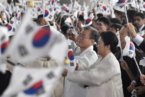South Korean President Moon Jae-in and his wife Kim Jung-sook wave national flags during a ceremony to mark the 74th anniversary of Korea's liberation from Japan's 1910-45 rule, Choenan, South Korea, 15 August 2019 (Photo: Reuters/Jung Yeon-je).