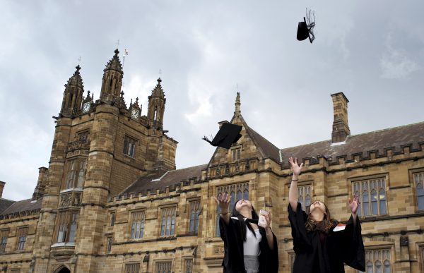 University students toss their graduation hats into the air for friends and family to take photos following their graduation ceremony at University of Sydney in Sydney, Australia, 22 April 2016, (Photo: Reuters/Jason Reed).