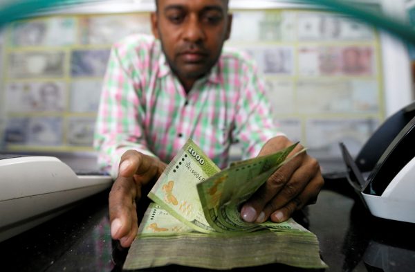 A man counts Sri Lankan rupees notes at a counter of a currency exchange shop in Colombo, Sri Lanka, 14 November 2017 (Photo: Reuters/Dinuka Liyanawatte).