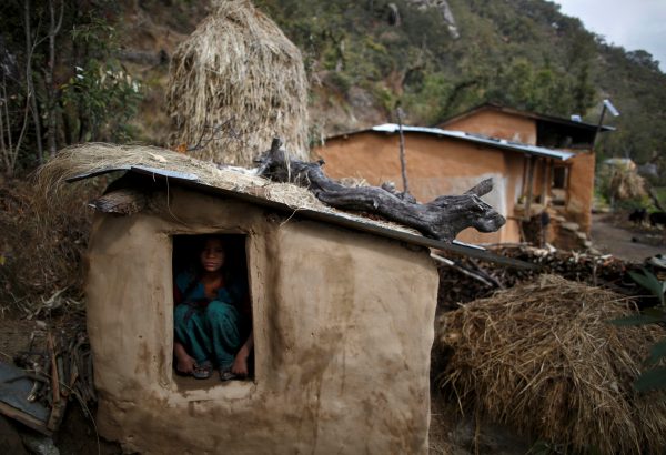 Uttara Saud, 14, sits inside a Chaupadi shed in the hills of Legudsen village in Achham District in western Nepal, 16 February 2014 (Photo: Reuters/Navesh Chitrakar/File Photo).