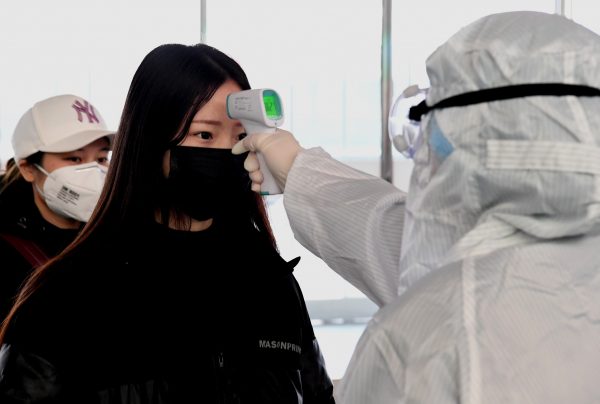 A staff member checks a passenger's body temperature at the entrance of Zhengzhou East Railway Station in Zhengzhou, central China's Henan Province, 1 Feb 2020 (Photo: Reuters).