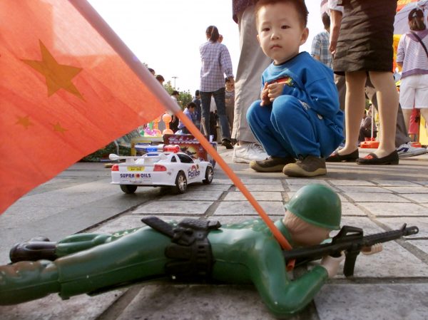 A boy looks at a motorized toy soldier on sale at a Shanghai sidewalk (Photo: REUTERS/Claro Cortes IV).