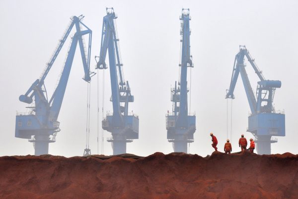 Workers remove the cloth covering iron ore from Australia while they prepare for transporting at a port in Tianjin, China, 29 March 2010 (Photo: Reuters/Vincent Du).