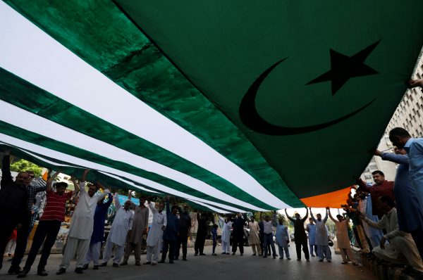 People carry an Azad Kashmir's flag as they listen to the speeches of the local political activists from Jammu and Kashmir Youth Forum, over India's decision to revoke the special status of Jammu and Kashmir, during a protest in Karachi, Pakistan 18 August 2019 (Photo: Reuters/Akhtar Soomro).