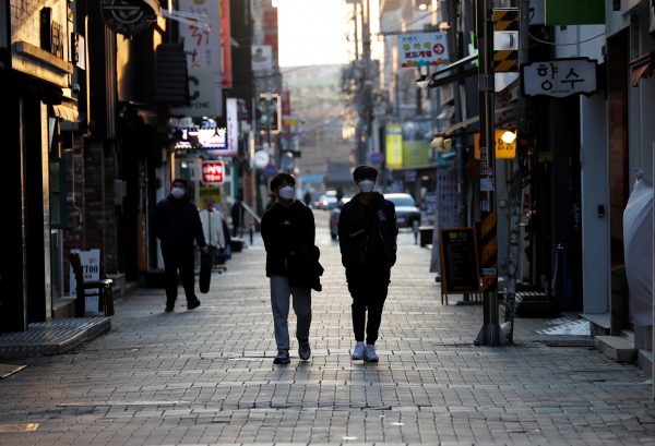 Pedestrians wearing masks amid the rise in confirmed cases of the novel coronavirus disease of COVID-19, make their way at a shopping district in Daegu, South Korea, 4 March 2020 (Reuters/Kim Kyung-Hoon).