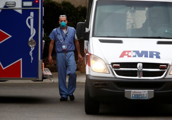 A doctor walks near an ambulance at the Life Care Center of Kirkland, a long-term care facility linked to several confirmed coronavirus cases, in Kirkland, Washington, United States, 5 March 2020 (Photo: Reuters/Lindsey Wasson ).