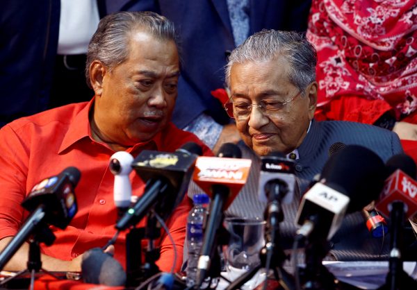 Former Malaysian Prime Minister Mahathir Mohamad listening to current Prime Minister Muhyiddin Yassin during a news conference, 5 April 2018 (Photos: Reuters/Lai Seng Sin).