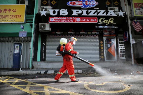 A worker sprays disinfectant on a street during the movement control order due to the outbreak of the coronavirus disease in Kuala Lumpur, Malaysia 28 March 2020 (Photo :Reuters/Lim Huey Teng).