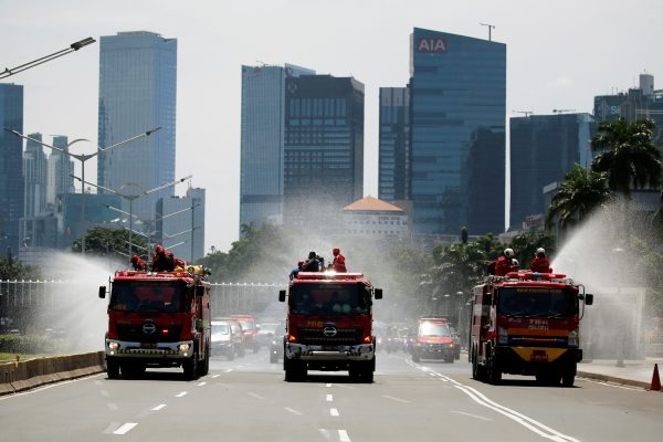Firefighters spray disinfectant using high pressure pump trucks to prevent the spread of coronavirus disease (COVID-19), on the main road in Jakarta, Indonesia, 31 March, 2020 (Reuters/Willy Kurniawan).