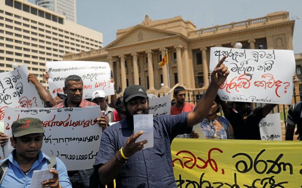 Members of Sri Lankan 'Movement for equal rights' shout slogans outside Sri Lanka's President Gotabaya Rajapaksa's office against the government's decision to issue death certificates for people who disappeared during the civil war, Placard in Sinhala reads: 'If missing people are dead, who killed them?' in Colombo, Sri Lanka, 11 February 2020 (Reuters/Dinuka Liyanawatte).