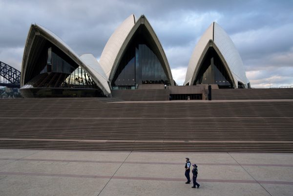 Police officers patrol near the Sydney Opera House following the implementation of stricter social-distancing and self-isolation rules to limit the spread of the coronavirus disease (COVID-19) in Sydney, Australia, 6 April 2020 (Photo: Reuters/Loren Elliott).