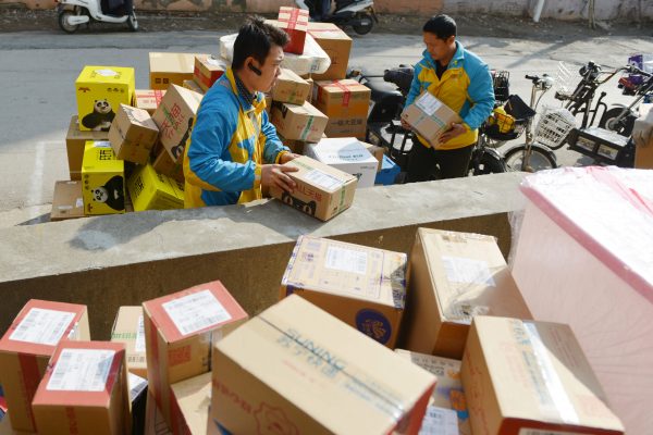 Workers of Chinese e-commerce retailer Suning Group sort out parcels at a distribution center of Suning in Nanjing city, east China's Jiangsu province, 13 November 2018.