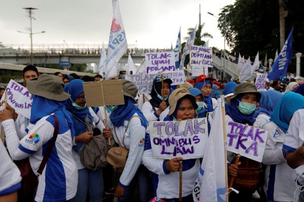 Women laborers carry placards stating 'Against Omnibus Law and Foreign Workers' as they participate in a protest outside Indonesia's parliament building in Jakarta, Indonesia, 20 January 2020 (Photo: Reuters/Willy Kurniawan).