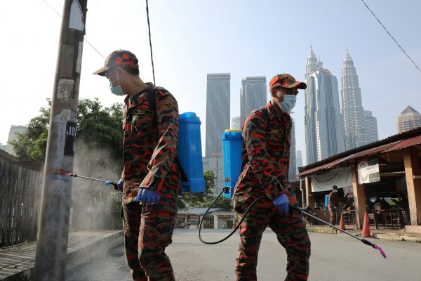 Firefighters spray disinfectant on a street during the movement control order due to the outbreak of the coronavirus disease (COVID-19), in Kuala Lumpur, Malaysia 31 March, 2020 (Photo: Reuters/Teng).