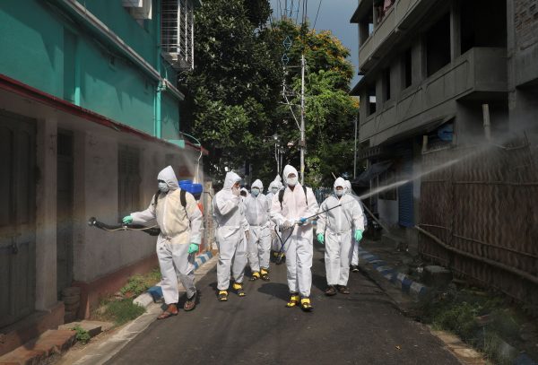 Municipal workers wearing protective gear spray disinfectant in a residential area during a nationwide lockdown to slow the spreading of COVID-19, Kolkata, India, 29 April 2020 (Photo:Reuters/Rupak De Chowdhuri).