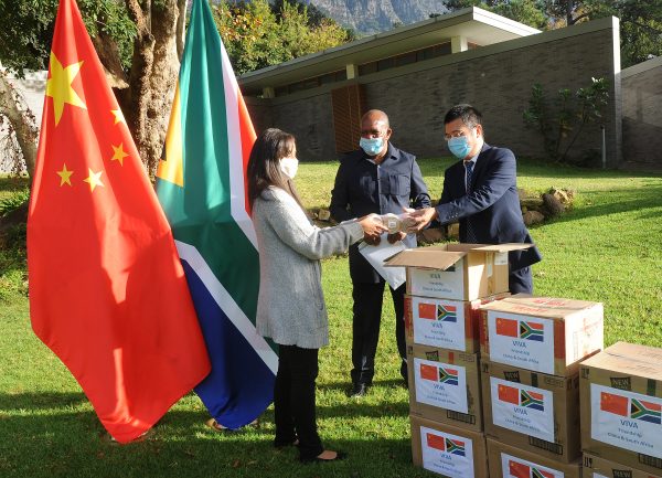 The Consulate General of the People's Republic of China, Lin Jing (right) delivered food and medical supplies to Vice President of Parliament Solomon Lechesa Tsenoli (center) in Cape Town, South Africa 13 May 2020 (Courtney Africa/ ANA/Latin America News Agency via Reuters).