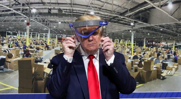 US President Donald Trump holds up a protective face shield during a tour of the Ford Rawsonville Components Plant that is manufacturing ventilators, masks and other medical supplies during the coronavirus disease (COVID-19) pandemic in Ypsilanti, Michigan, 21 May 2020 (Photo: REUTERS/Leah Millis).