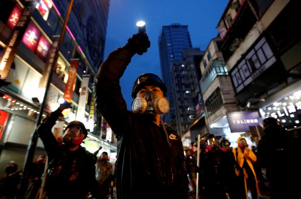 Demonstrators protesting the proposed extradition bill aim their flashlights towards riot police as they are chased through the streets of Hong Kong, China, 25 August , 2019 (Photo: Reuters/Kurniawan).