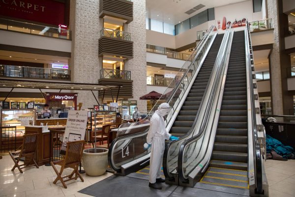 A janitor wearing a hazmat suit to prevent the spread of the coronavirus disease (COVID-19) cleans the rails of an escalator in an almost empty shopping mall in Mandaluyong City, Metro Manila, Philippines 3 June 2020 (Photo: Reuters/Eloisa Lopez).