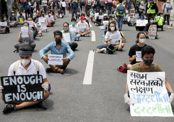 Protesters with placards protest near the Prime Minister's official residence, demanding better and effective response from the government to fight COVID-19 outbreak as the number of infections spikes, in Kathmandu, Nepal, 9 June 2020 (Photo: Reuters/Navesh Chitrakar).
