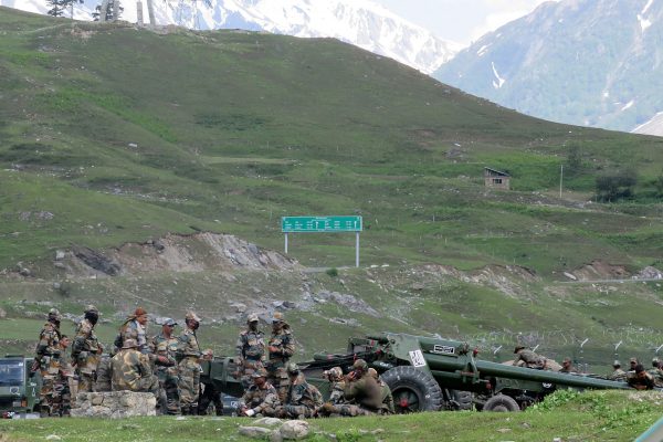 Indian army soldiers rest next to artillery guns at a makeshift transit camp before heading to Ladakh, 16 June 2020 (Photo: Reuters/AH).