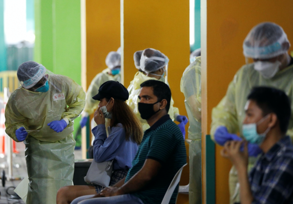 Essential workers have their noses swabbed before returning to the workforce at a regional screening center amid the coronavirus disease (COVID-19) outbreak in Singapore 9 June, 2020 (Photo: Reuters/Edgar Su).