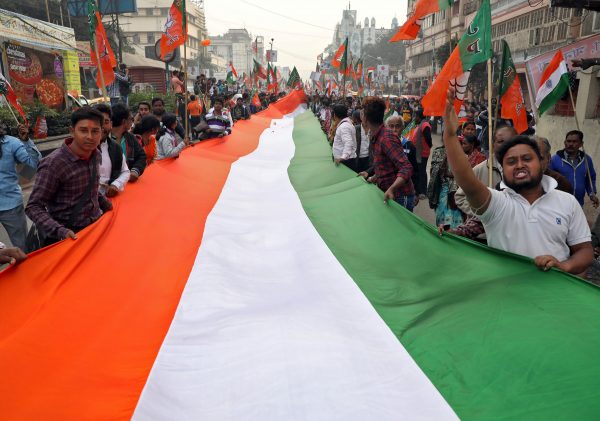 Supporters of India's ruling Bharatiya Janata Party shout slogans as they hold an Indian flag during a march in support of a new citizenship law, in Kolkata, India, 23 December 2019 (Photo: Reuters/Rupak De Chowdhuri).