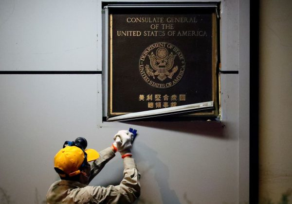 A man works to remove the US Consulate plaque at the US Consulate General in Chengdu, Sichuan province, China, 26 July 2020 (Photo: Reuters/Thomas Peter).
