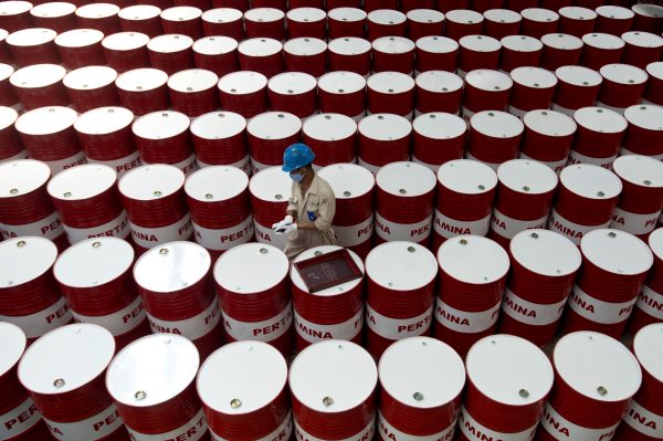 A worker prepares to label barrels of oil at the state oil company Pertamina's production facility in Cilacap, Central Java, Indonesia, 6 November 2017 (Photo: Antara Foto/Rosa Panggabean via Reuters).