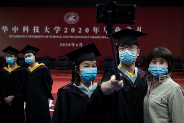 Huazhong University of Science and Technology (HUST) holds annual graduation ceremony in Guanggu Stadium, with around 300 graduates being on site, and thousands of students witness the ceremony online, and take photos with classmates through tablets, Wuhan City, central China's Hubei province, 21 June 2020 (Reuters).