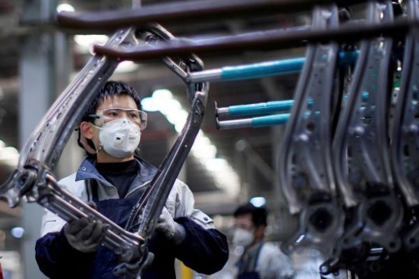 An employee wearing a face mask works on a car seat assembly line at Yanfeng Adient factory in Shanghai, China, as the country is hit by an outbreak of the new coronavirus disease (COVID-19), 24 February 2020 (Photo: Reuters/Aly Song).
