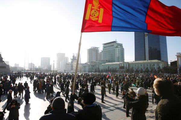 A protester waves a Mongolian flag during a demonstration at Sukhbaatar Square in Ulaanbaatar, Mongolia, 27 December 2018 (Photo: Reuters/B. Rentsendorj).