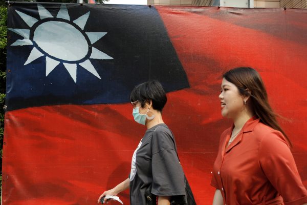 People walk past a Taiwanese flag amid COVID-19 in Taipei, Taiwan, 10 August 2020 (Photo: Reuters/Ann Wang).