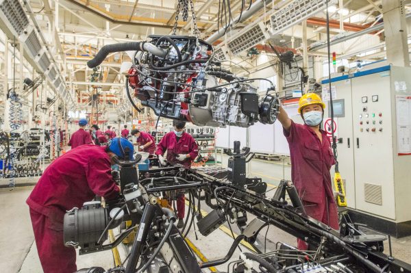 Workers are busy at assembling a vehicle along the production line at a workshop of Shandong branch of Chinese state-owned automobile and commercial vehicle manufacturer JAC Motors, Qingzhou county-level city, Weifang city, east China's Shandong province, 31 May 2020 (Reuters).