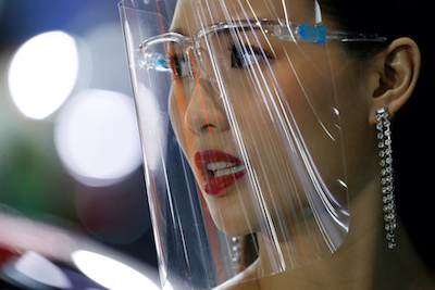 A promoter wears a face shield during the 41st Bangkok International Motor Show, after the Thai government eased measures to prevent the spread of the coronavirus disease (COVID-19), in Bangkok, Thailand, 15 July, 2020 (Photo: Reuters/Silva).
