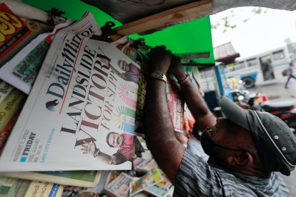 A man hangs newspapers carrying headlines about the victory of Mahinda Rajapaksa's Sri Lanka People's Front party in the country's parliamentary election in Colombo, Sri Lanka, 7 August , 2020 (Photo: Reuters/Dinuka Liyanawatte).
