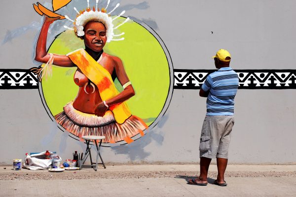 A local artist checks his work as he puts the finishing touches to a mural as part of preparations for the Asia Pacific Economic Cooperation (APEC) forum in Port Moresby, Papua New Guinea, 15 November 2018 (Photo: Reuters/David Gray).