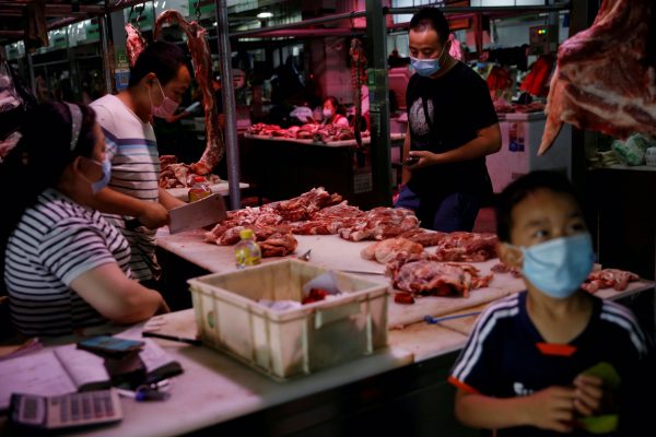 Customers wearing face masks buy mutton inside the Yuegezhuang wholesale market, following new cases of coronavirus disease (COVID-19) infections in Beijing, China, 17 June, 2020 (Reuters/Tingshu Wang).