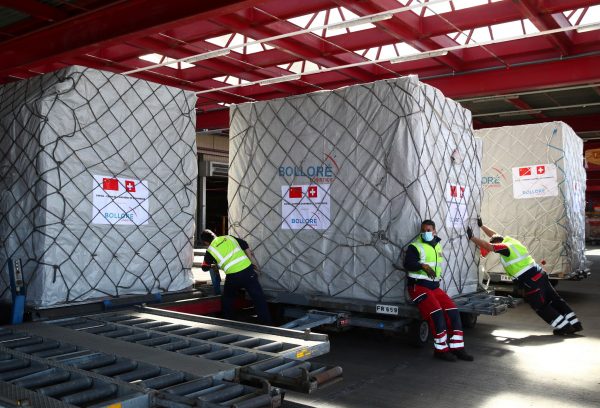Swissport staff members take care of cargo of masks imported by the Chinese-Swiss Chamber of Congress and the Geneva Chamber of Commerce at Cointrin airport in Geneva, 6 April 2020 (Photo: Reuters/Denis Balibouse).